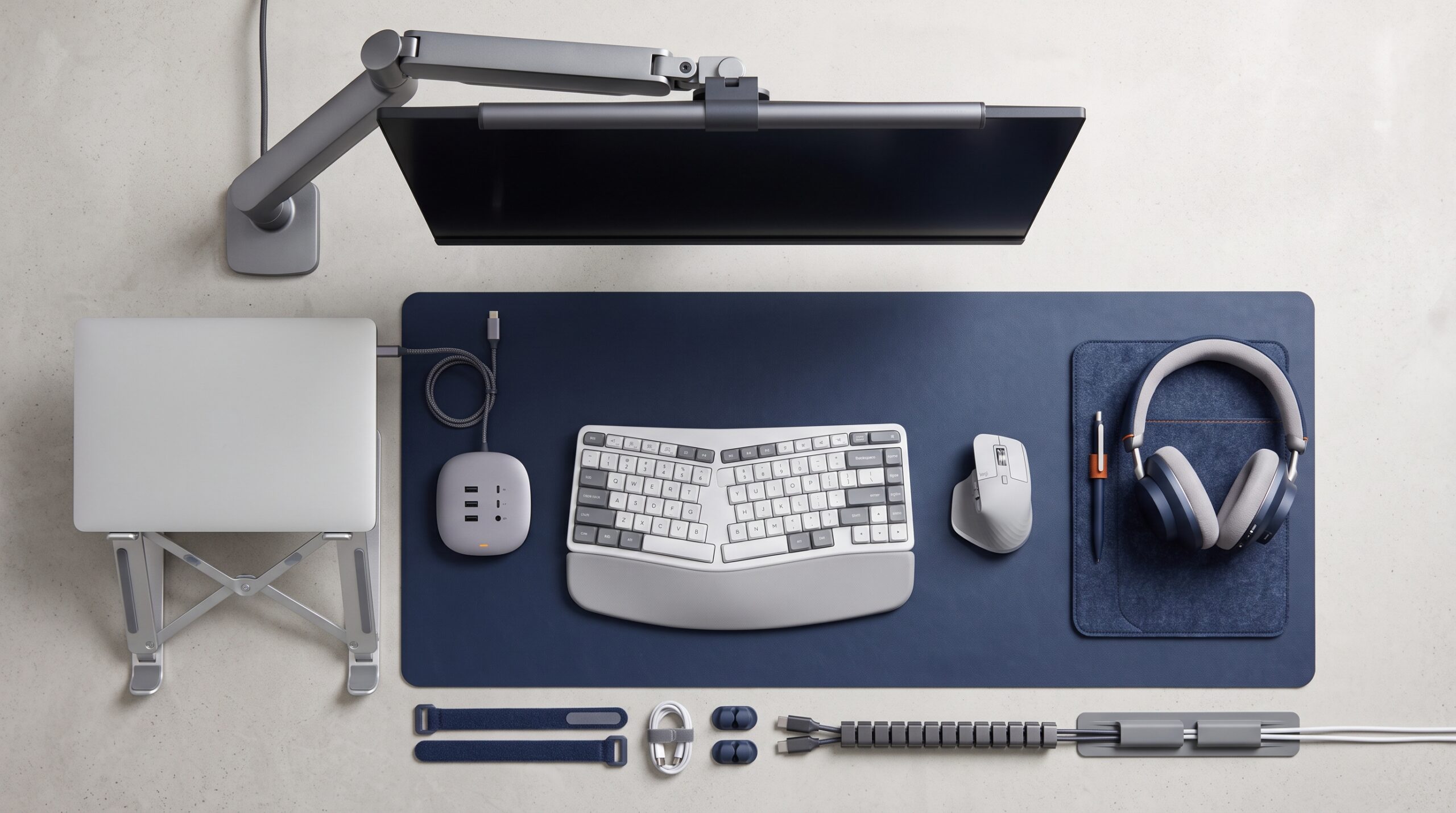 Essential desk accessories for focus, including a laptop stand, dock, headset, ergonomic peripherals, and cable management tools.